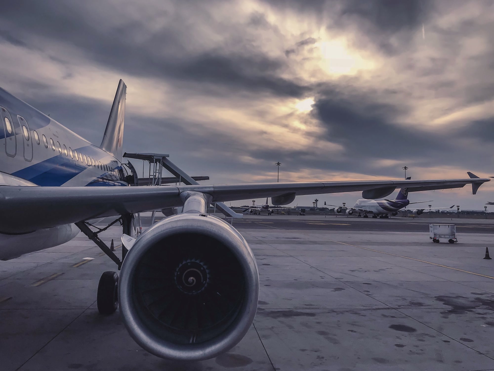 Jet engine and wing on the tarmac at dusk